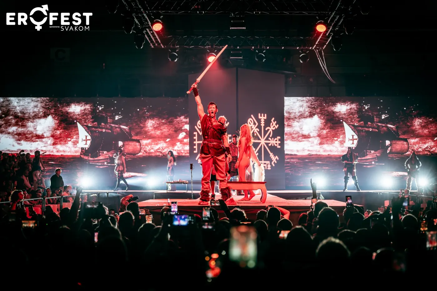Vystupující s mečem nad hlavou při show na hlavní stage před davem s telefony